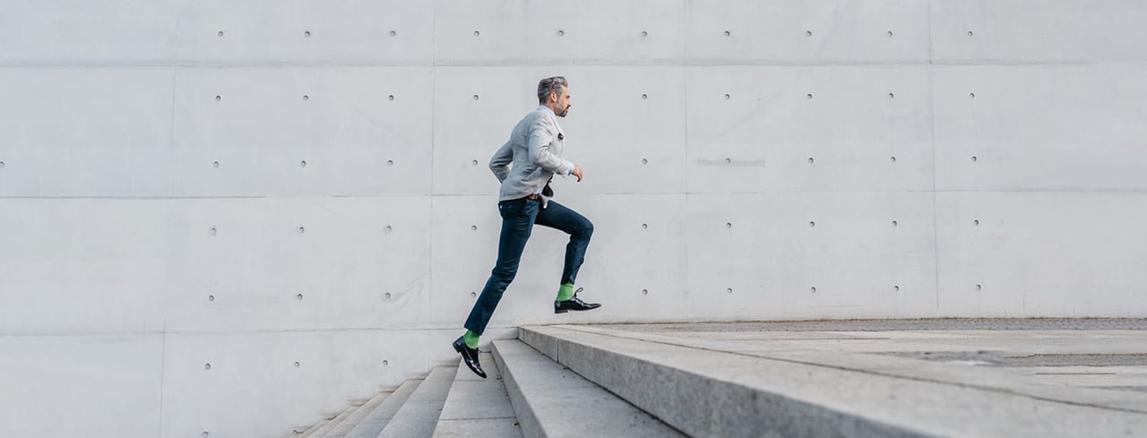 Ein Mann mit grünen Socken, der eine Treppe hochläuft